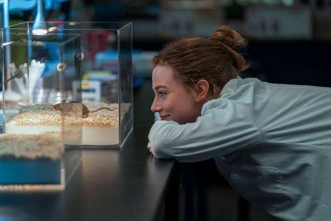 Character (Olive) happily watching mice in a biology lab.